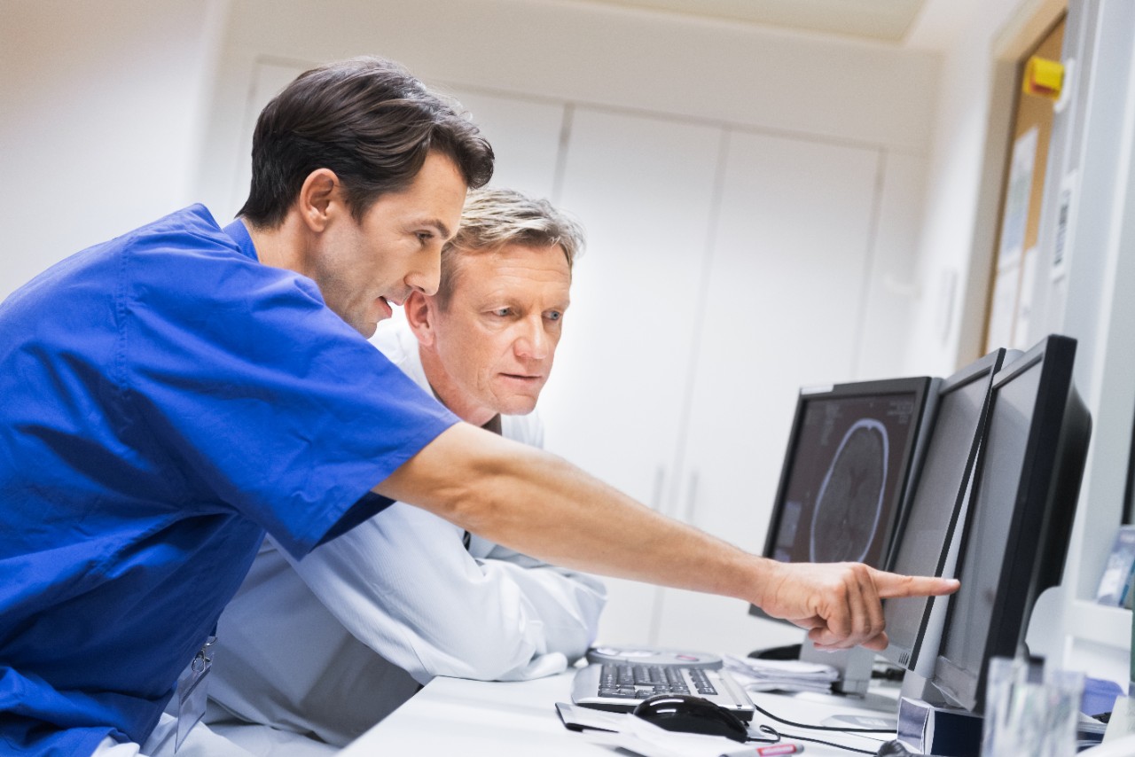 Doctors Discussing CAT Scans on a Monitor